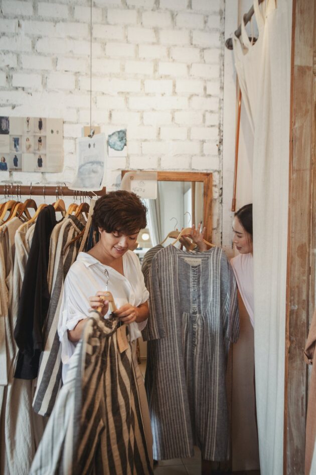 Stylish young ethnic female customers exploring new collection of fashion boutique